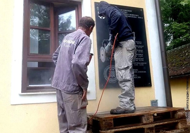 Радници скидају плочу ХОС-а у Јасеновцу