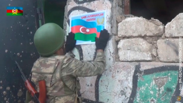 Azerbejdžanski vojnik lepi nalepicu državne zastave na osvojenom položaju Azerbejdžanski vojnik lepi nalepicu državne zastave na osvojenom položaju