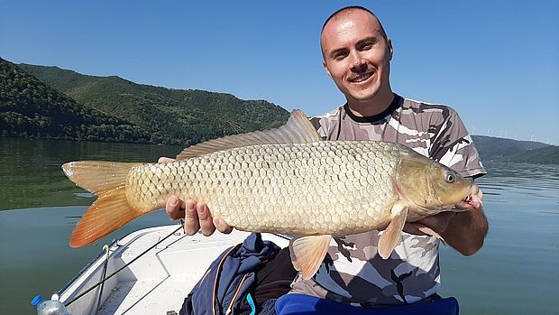 Спортски риболовац са уловљеним капиталним шараном