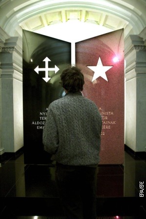 Posetilac stoji ispred granitnih stubova posvećenih žrtvama nacizma i komunizma na glavnom ulazu u muzej 