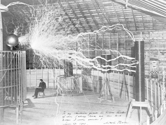 Tesla u svojoj laboratoriji u Kolorado Springsu unutar svog „Uveličavajućeg prenosnika” koji proizvodi milione volti napona